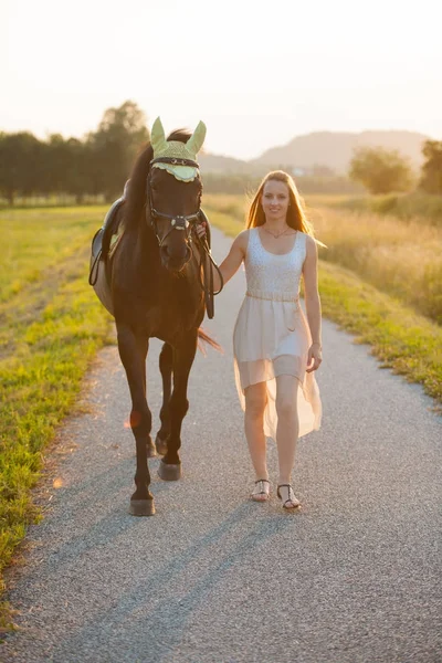 Bella giovane donna con cavallo all'aperto in una passeggiata nella natura — Foto Stock