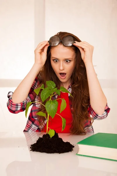 Attraktive junge Botanikstudentin mit Saatgut und Büchern — Stockfoto