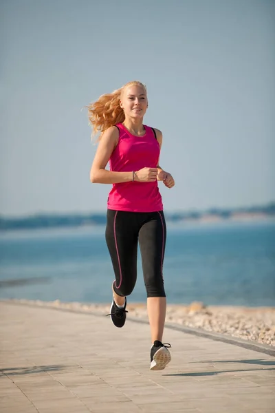 Joggen in th strand - vrouw runns in de buurt van de zee op vroege zomer morni — Stockfoto
