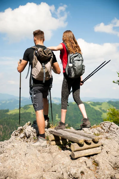 Ativo Bonito casal jovem caminhadas ina natureza escalada colina ou — Fotografia de Stock