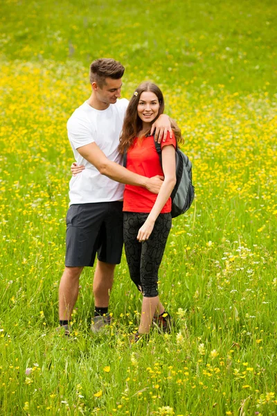 Active Playful coupel hiking on a meadow in ratly spring green g — Stock Photo, Image