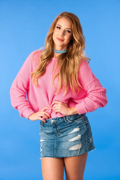 Krásná mladá žena v džínách sukni a růžový svetr — Stock fotografie