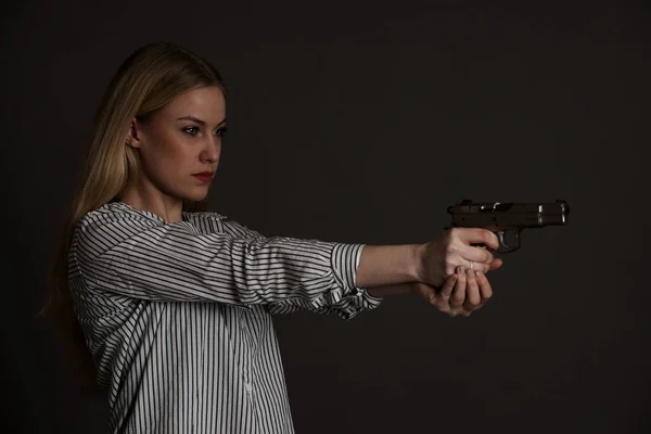 Młodych niebezpieczne blond kobieta z pistoletu — Zdjęcie stockowe