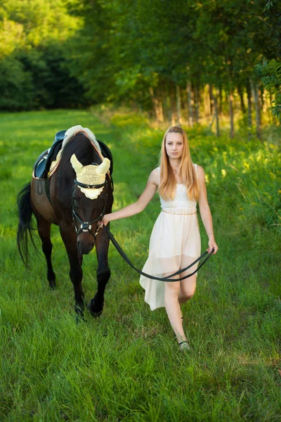 Bella giovane donna con cavallo all'aperto in una passeggiata nella natura — Foto Stock