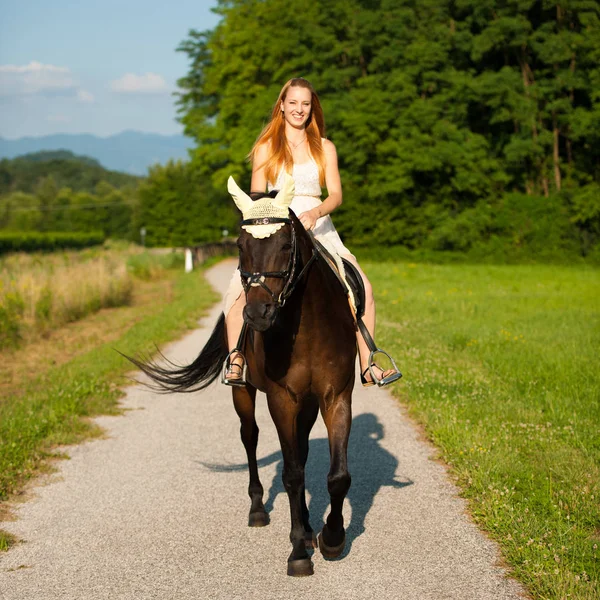 Giovane donna attiva cavalcare un cavallo nella natura — Foto Stock