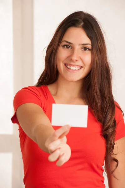 Όμορφη νεαρή γυναίκα με κόκκινο t πουκάμισο κατέχει κενή κάρτα πάνω από λευκό — Φωτογραφία Αρχείου