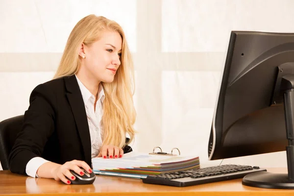 Hermosa joven rubia trabajando en la computadora en su oficina — Foto de Stock