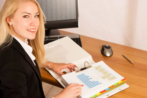 Beautiful young woman check data in a work folder in her office — Stock Photo, Image