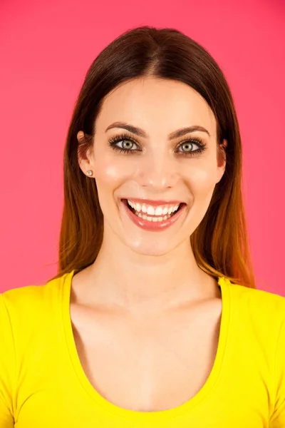 Funky young woman in yellow  t shirt pose over pink background — Stock Photo, Image