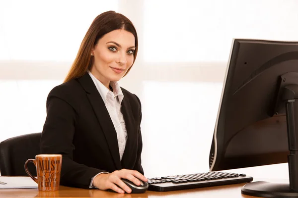 Attraente giovane donna d'affari lavora alla sua scrivania in ufficio — Foto Stock