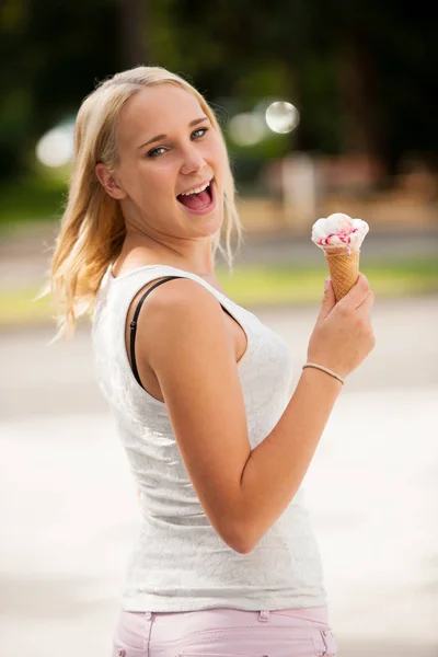 Woman eating ice cream in a park on a hot summer day — Stock Photo, Image