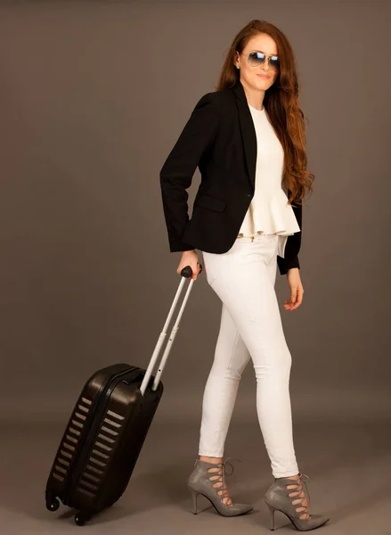 Привлекательная деловая женщина с чемоданом - студия для деловых поездок — стоковое фото