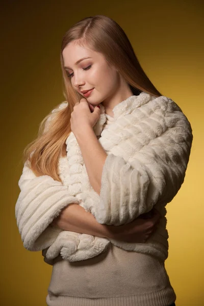 Beauty portrait of woman in fur winter jacket over yellow backgr — Stock Photo, Image