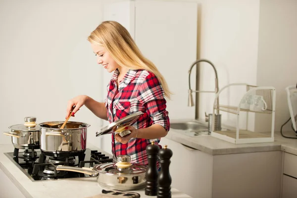 Красивая молодая женщина на кухне готовит вкусную еду — стоковое фото