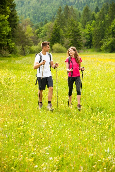 Ativo Bonito casal jovem caminhadas ina natureza escalada colina ou — Fotografia de Stock