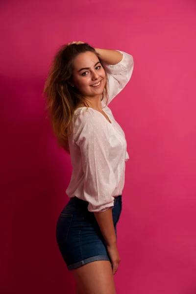 Leuke jonge vrouw in lichte zomer kleding op roze achtergrond — Stockfoto