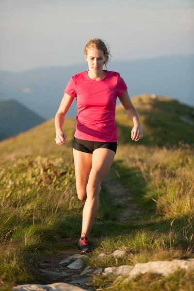 La mujer corre en la cima de las montañas con la cordillera en la espalda —  Fotos de Stock