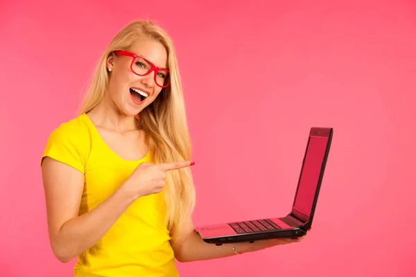 Gyönyörű fiatal nő tart egy laptop gesztus meglepetés és a siker — Stock Fotó