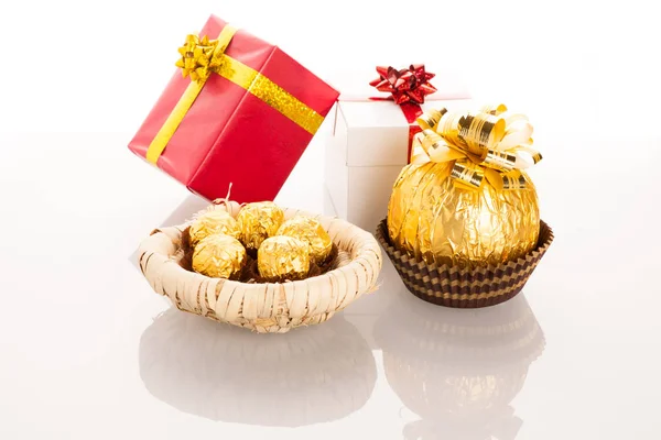 Big round chocolate candy wrapped in golden foil with big bow on Stock Picture