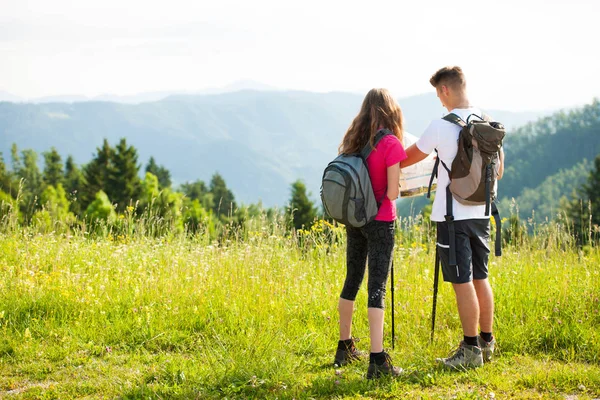 Ativo Bonito casal jovem caminhadas ina natureza escalada colina ou — Fotografia de Stock