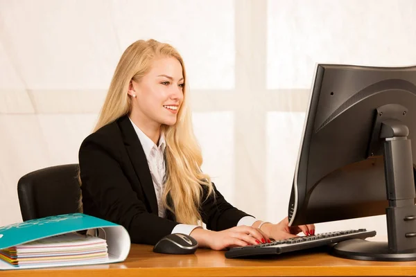 Hermosa joven rubia trabajando en la computadora en su oficina — Foto de Stock