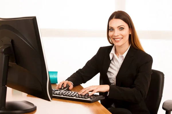 Aantrekkelijke jonge zakenvrouw werkt bij haar Bureau in het kantoor — Stockfoto