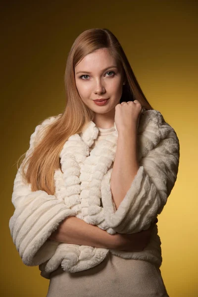 Portret van de schoonheid van de vrouw in bont winter jas over gele backgr — Stockfoto