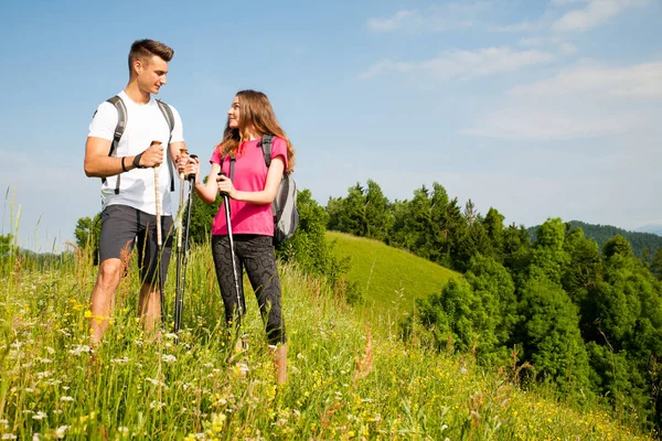 Ativo Bonito casal jovem caminhadas ina natureza escalada colina ou — Fotografia de Stock