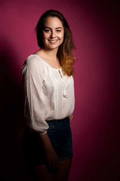 Leuke jonge vrouw in lichte zomer kleding op roze achtergrond — Stockfoto