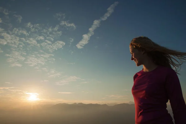 Woamn se dresse sur un sommet de montagne au coucher du soleil — Photo