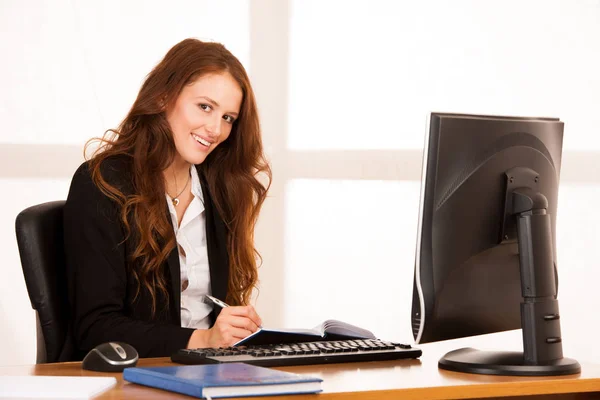 Beautiful young business woman work at her desk in the office wi — Stock Photo, Image