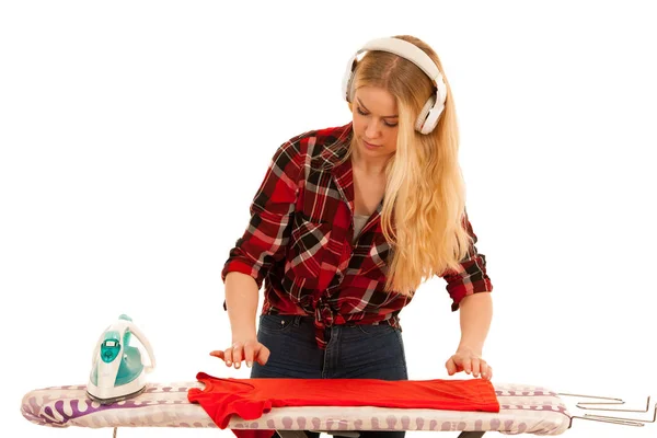 Mujer rubia joven escucha música y canta mientras plancha — Foto de Stock