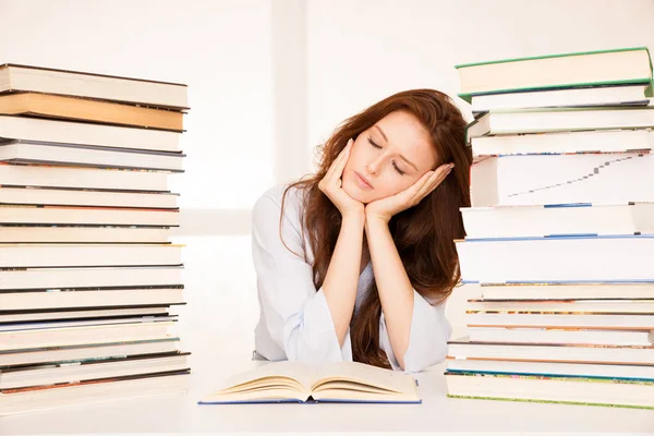 Aantrekkelijke jonge vrouw studies met hugr boek stapels op haar Bureau — Stockfoto