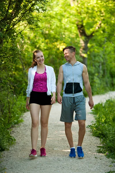 Aktives junges Pärchen auf einem Spaziergang im Park — Stockfoto