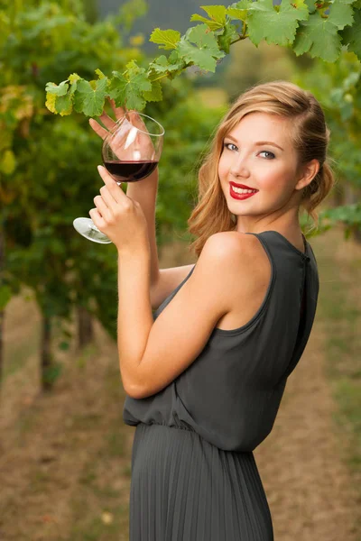 Attrayant élégant femme boire un verre de vin rouge dans le vignoble — Photo