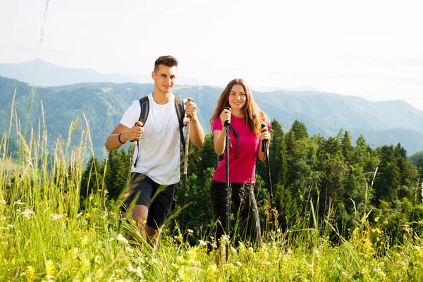 Ativo Bonito casal jovem caminhadas ina natureza escalada colina ou — Fotografia de Stock