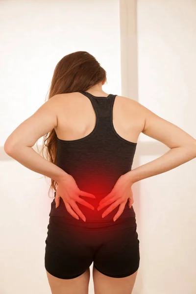 Terug van letsel - actieve jonge vrouw gewond zijn rug — Stockfoto