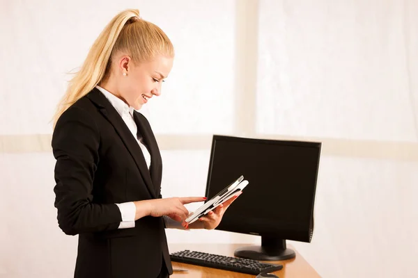 Güzel genç iş kadını tablet iade etme üzerinde web sörf — Stok fotoğraf