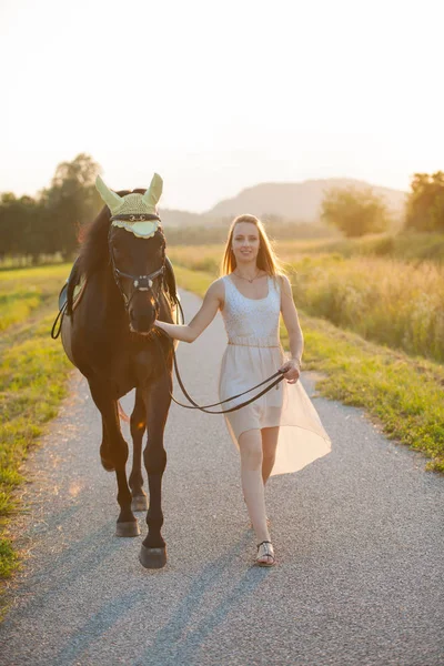 Bella giovane donna con cavallo all'aperto in una passeggiata nella natura — Foto Stock