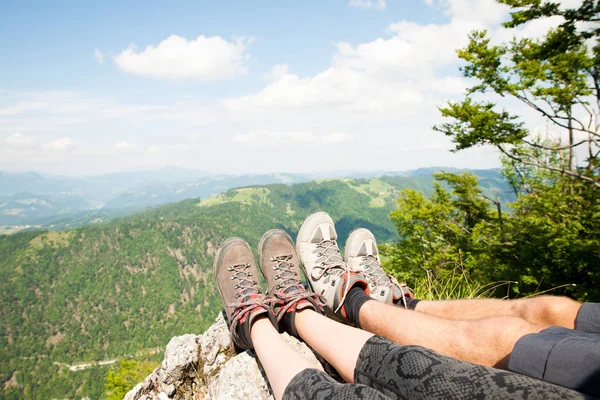 Vista montanha sobre as pernas das mulheres enquanto ela descansa no pico da montanha — Fotografia de Stock