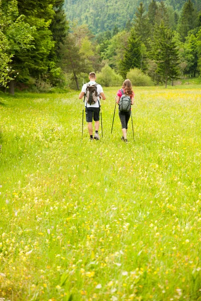 Ativo Bonito casal jovem caminhadas ina natureza escalada colina ou — Fotografia de Stock