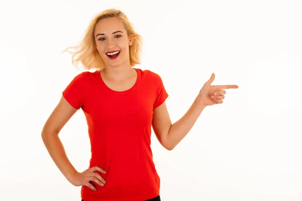 Attractive beautiful young blonde woman pointing into copyspace — Stock Photo, Image