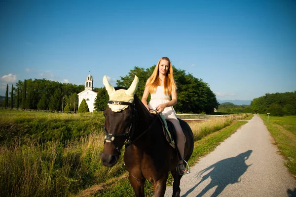 Giovane donna attiva cavalcare un cavallo nella natura — Foto Stock