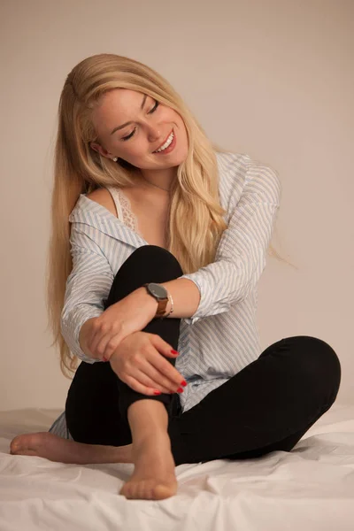 Hermosa joven rubia picando en la cama — Foto de Stock