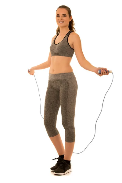 Beautiful young fit woman works out with speed rope isolated ove — Stock Photo, Image