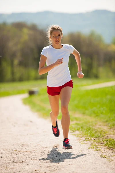 Corredora mujer corre - entrenamiento en primavera —  Fotos de Stock