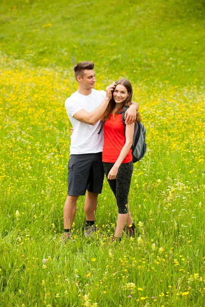 Active Playful coupel hiking on a meadow in ratly spring green g — Stock Photo, Image