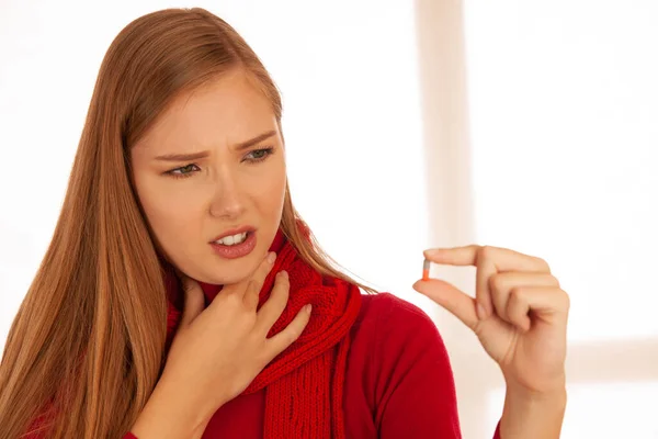 Wanita Muda Bersweater Merah Memegang Pil Tangannya Saat Dia Sakit — Stok Foto
