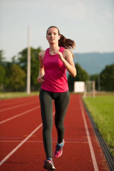 美しい若い女性のランナーは初夏の午後にトラック上で実行されます — ストック写真