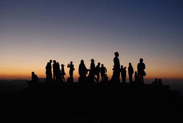 Silhouet mensen bij zonsondergang . Stockfoto